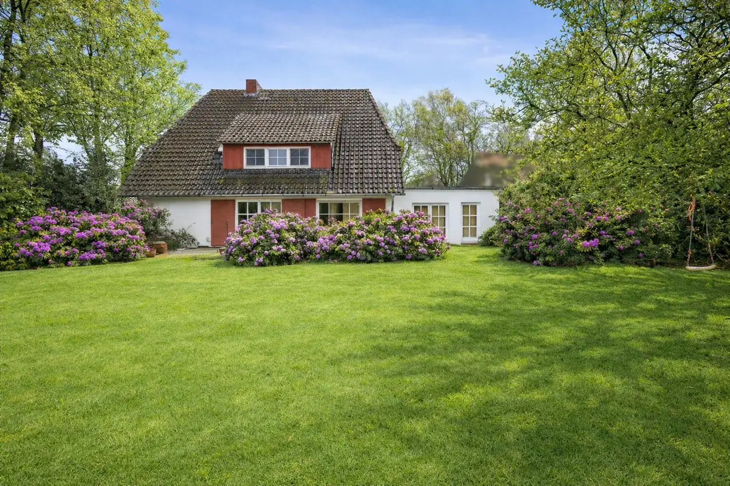 Einfamilienhaus in Tewel bei Neuenkirchen, Gartenseite mit Rhododendren